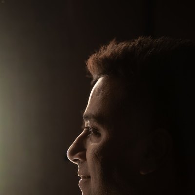 An actor in profile, rim-lit against black
