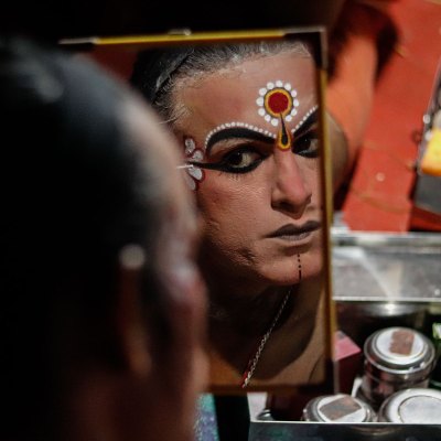 An actor applying character makeup before a performance