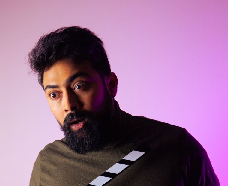 An actor reacting to a take, clapperboard in hand