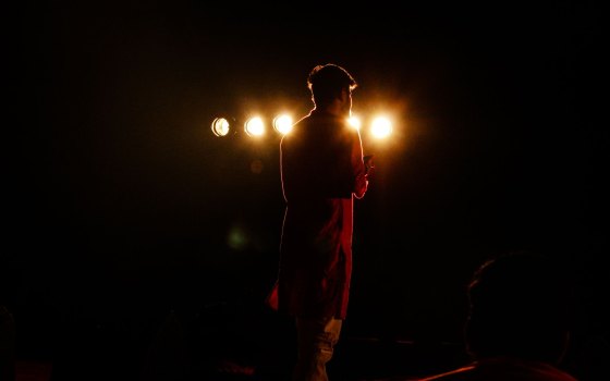 A performer alone in a stage backlight
